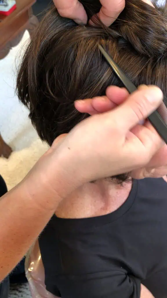 Stylist cutting and styling a custom wig on a client at Charle a Hair Studio in Carlsbad